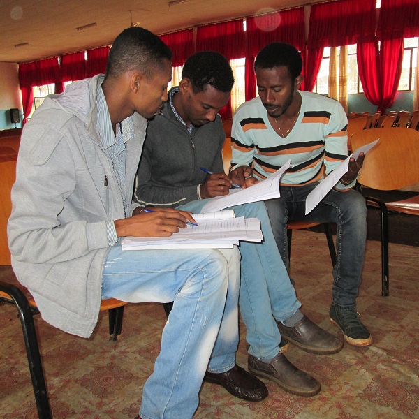 Men studying Borna literacy materials
